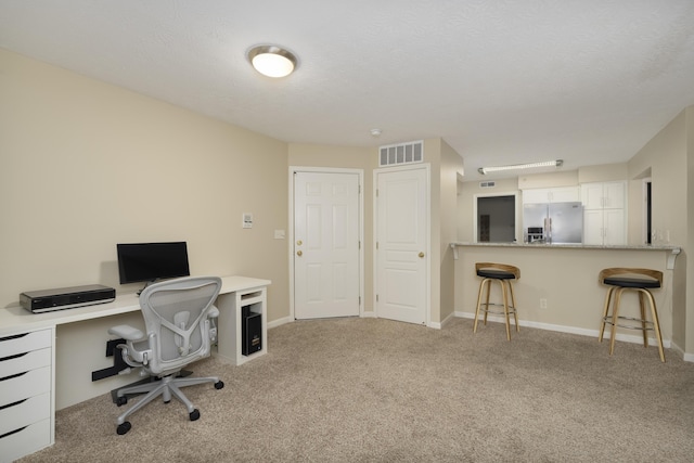 carpeted office space featuring a textured ceiling