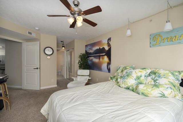 carpeted bedroom with ensuite bathroom and ceiling fan