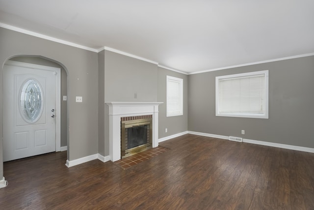 unfurnished living room with ornamental molding, dark hardwood / wood-style flooring, and a brick fireplace