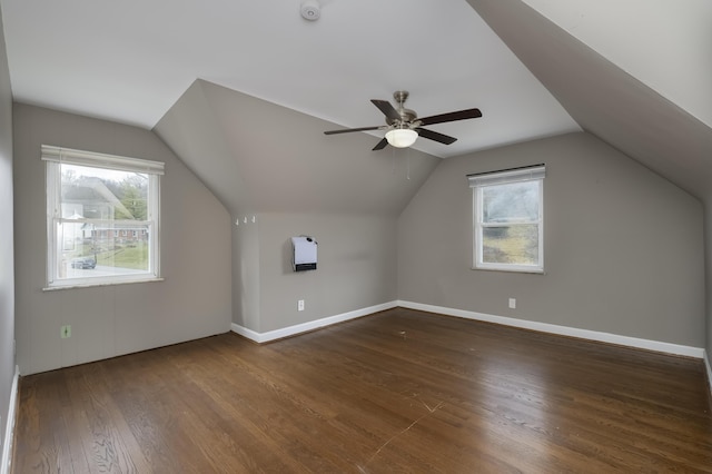 additional living space featuring dark hardwood / wood-style flooring, vaulted ceiling, and ceiling fan