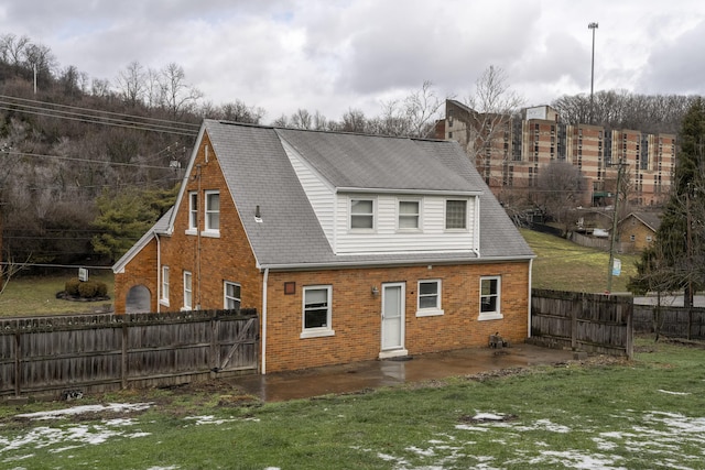 back of property featuring a lawn and a patio