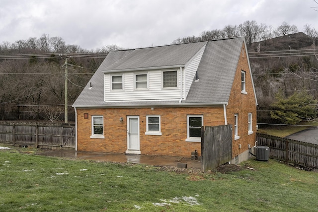 view of front of house featuring central AC and a front yard