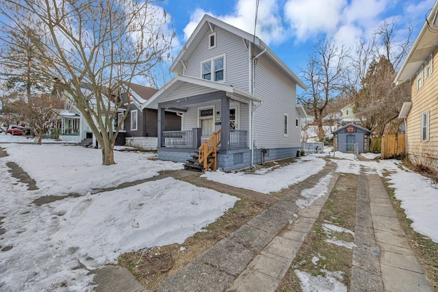 bungalow-style house featuring a storage shed and covered porch