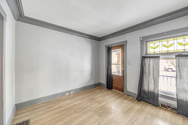 unfurnished room with ornamental molding and light hardwood / wood-style floors