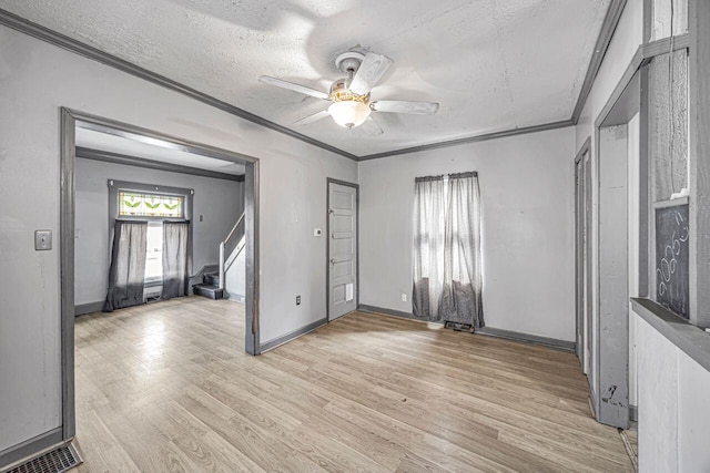 entrance foyer with crown molding, ceiling fan, a textured ceiling, and light hardwood / wood-style flooring