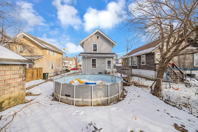 view of snow covered back of property