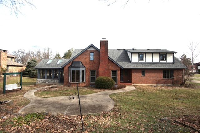 back of house featuring a lawn and a sunroom