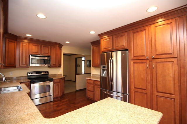 kitchen featuring light stone countertops, appliances with stainless steel finishes, sink, and dark wood-type flooring