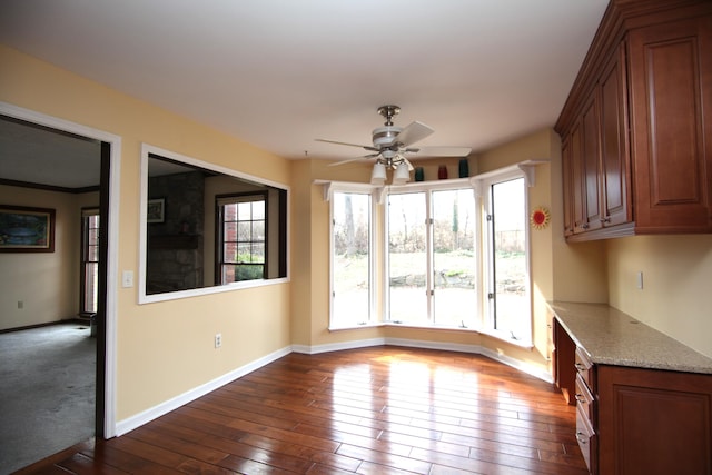 unfurnished dining area featuring ceiling fan and dark hardwood / wood-style flooring