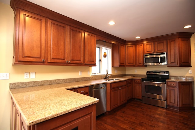 kitchen featuring sink, dark wood-type flooring, light stone countertops, and appliances with stainless steel finishes