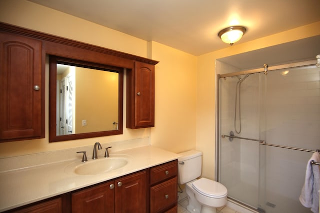 bathroom featuring vanity, toilet, and a shower with shower door