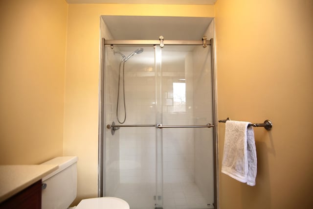 bathroom with toilet and an enclosed shower