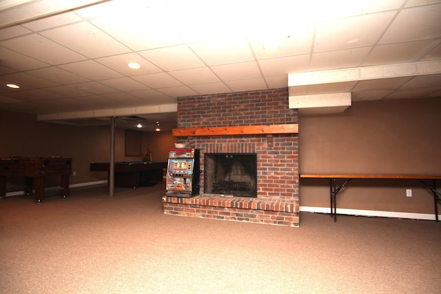 unfurnished living room with carpet, a drop ceiling, and a fireplace