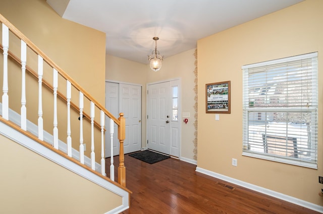 entryway with dark hardwood / wood-style floors and a healthy amount of sunlight