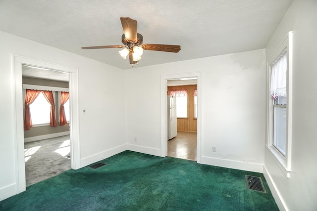 carpeted spare room with a textured ceiling