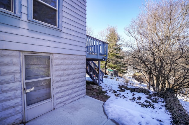 view of snow covered exterior with a deck