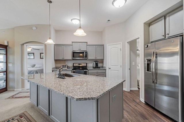 kitchen with gray cabinets, sink, hanging light fixtures, stainless steel appliances, and light stone countertops