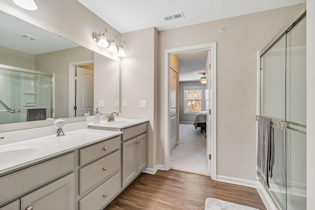 bathroom featuring hardwood / wood-style flooring, vanity, and an enclosed shower