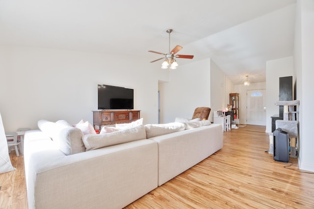 living area with light wood-style flooring, ceiling fan, and vaulted ceiling