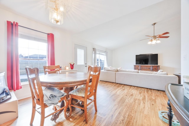 dining room featuring vaulted ceiling, ceiling fan with notable chandelier, and wood finished floors