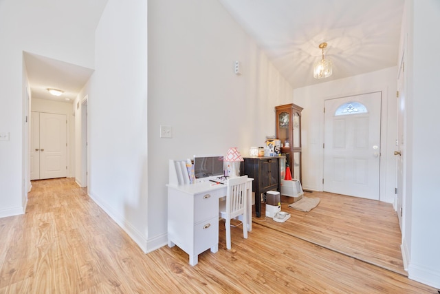 foyer with baseboards and light wood-style floors