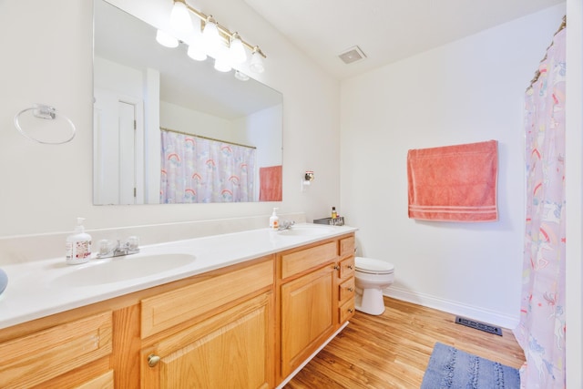 full bath featuring a sink, visible vents, wood finished floors, and double vanity