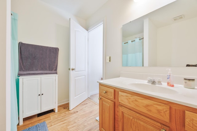 bathroom featuring vanity, curtained shower, wood finished floors, and visible vents