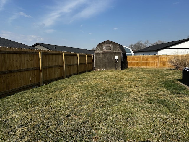 view of yard featuring an outbuilding, a fenced backyard, and a shed