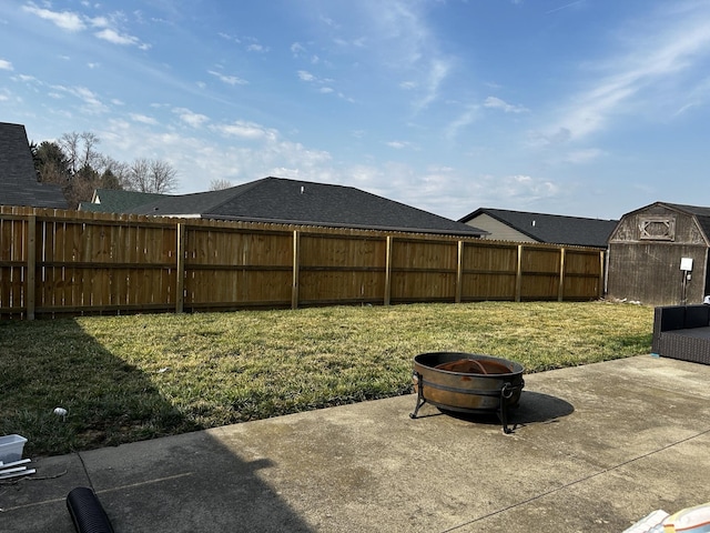 view of yard with a patio area, an outbuilding, a fire pit, and fence