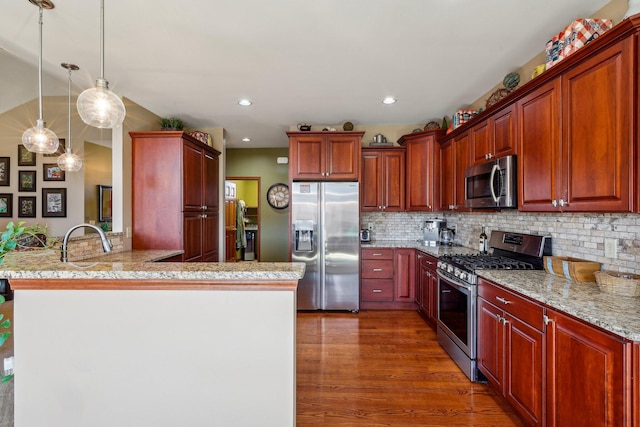 kitchen with hanging light fixtures, dark hardwood / wood-style flooring, kitchen peninsula, stainless steel appliances, and backsplash