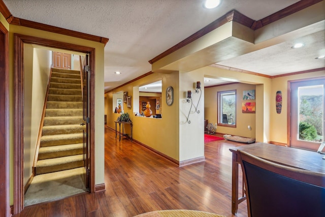 interior space featuring ornamental molding, plenty of natural light, dark wood-type flooring, and a textured ceiling