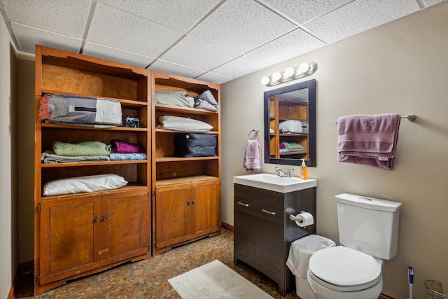 bathroom featuring a paneled ceiling, vanity, and toilet