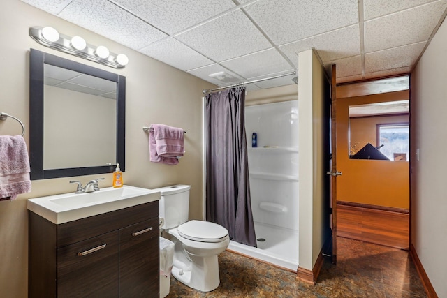 bathroom with a drop ceiling, vanity, toilet, and a shower with shower curtain