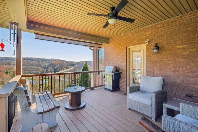 wooden deck with ceiling fan, a grill, and a mountain view