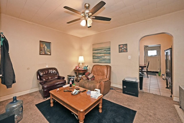 carpeted living room with crown molding and ceiling fan