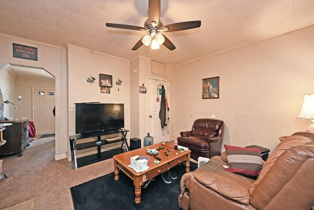 carpeted living room featuring ornamental molding and ceiling fan