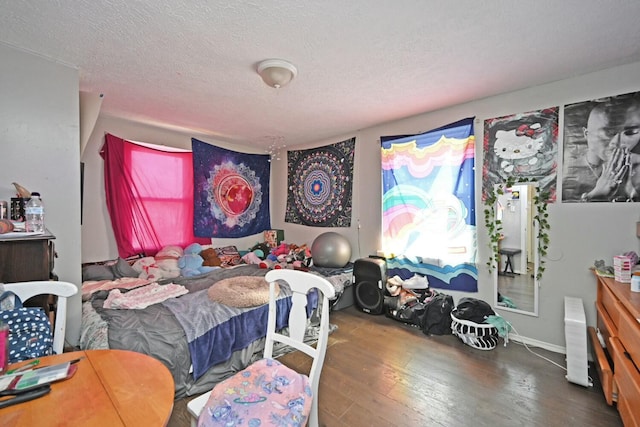 bedroom with dark hardwood / wood-style floors and a textured ceiling