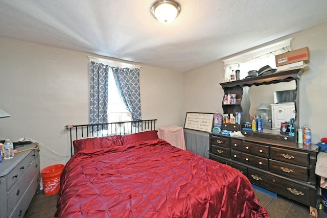 bedroom with dark hardwood / wood-style floors and a textured ceiling