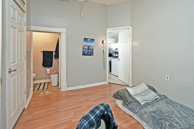 bedroom with connected bathroom and light hardwood / wood-style flooring