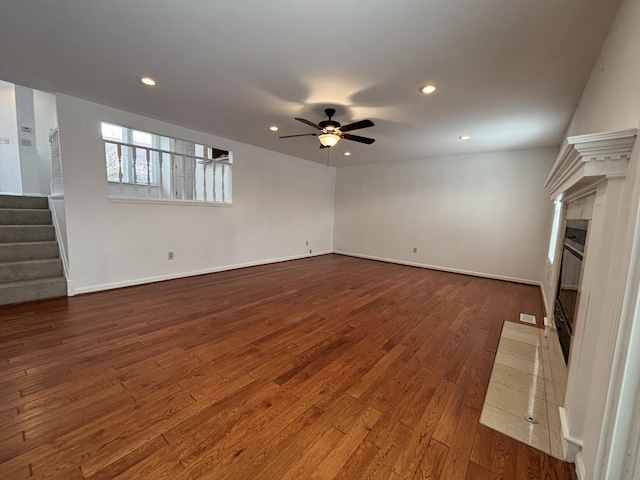 unfurnished living room featuring ceiling fan and dark hardwood / wood-style floors