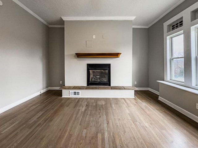 unfurnished living room with crown molding, a textured ceiling, and dark hardwood / wood-style flooring