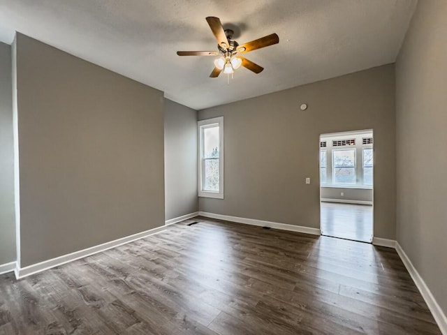 empty room featuring ceiling fan and dark hardwood / wood-style flooring