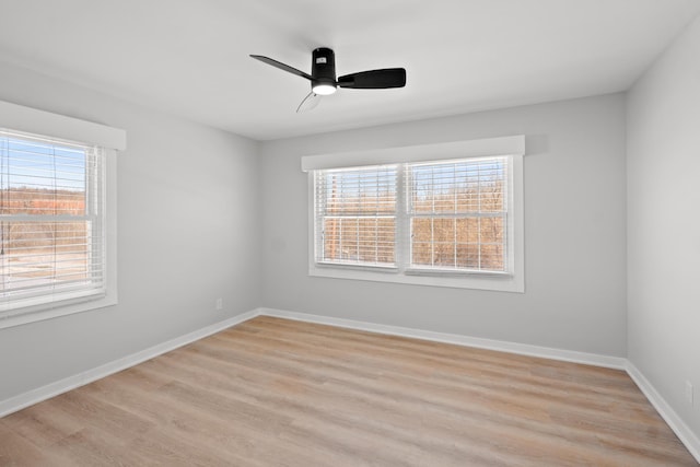 spare room with plenty of natural light, ceiling fan, and light hardwood / wood-style flooring