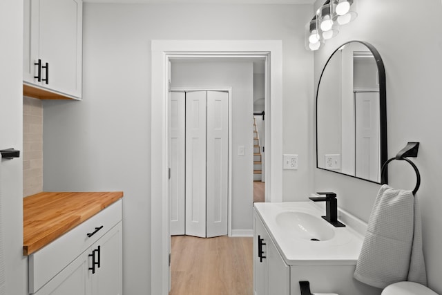 bathroom with vanity, hardwood / wood-style floors, and decorative backsplash