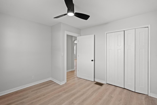 unfurnished bedroom with ceiling fan, a closet, and light hardwood / wood-style flooring