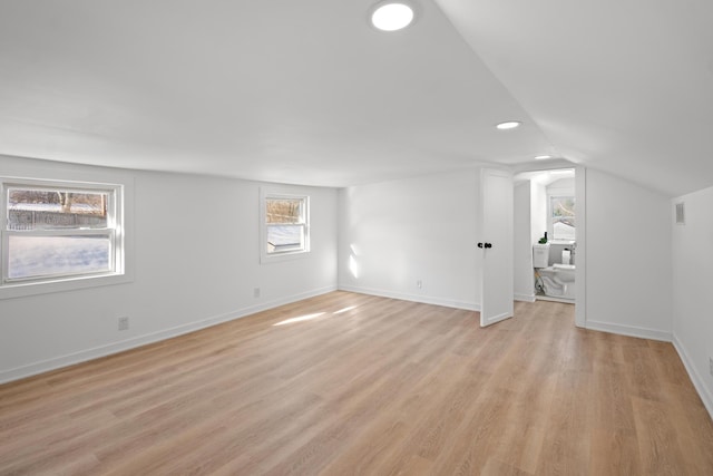 additional living space with lofted ceiling and light hardwood / wood-style flooring