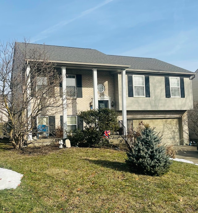 raised ranch with a garage and a front yard