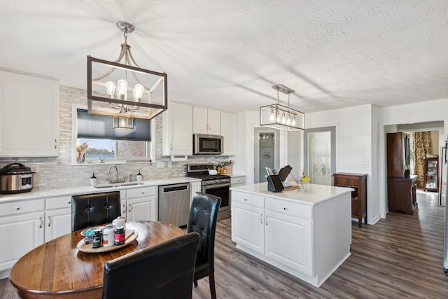 15027 Madison Pike, Morning View, KY 41063 - kitchen with stainless steel appliances, a sink, backsplash, dark wood-style flooring, and a chandelier