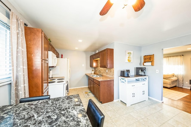 kitchen with light tile patterned flooring, sink, backsplash, and white appliances