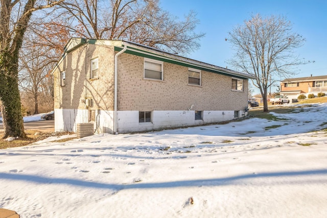 snow covered rear of property with cooling unit